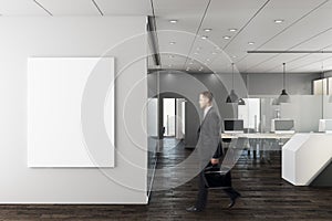 Businessman in modern office with empty wall