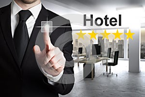 Businessman in modern office pushing touchscreen hotel rating five stars