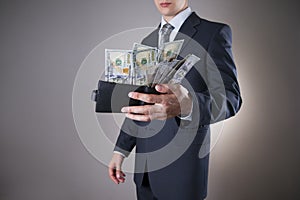Businessman with money in studio on a gray background