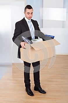 Businessman moving out with cardboard box