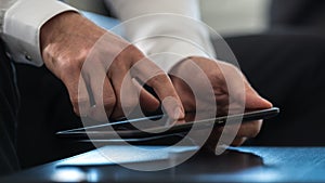 Businessman navigating a tablet computer activating the touchscreen with a finger