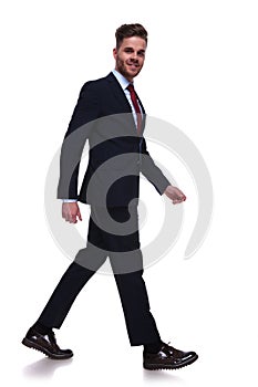 Businessman in navy suit and red tie stepping to side