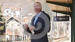 Businessman With Newspaper in Hand Waiting Train Railway Station