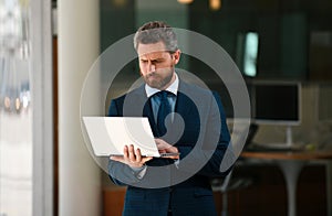 Businessman with notebook outdoor. Confident business expert. Handsome man in suit holding laptop against office