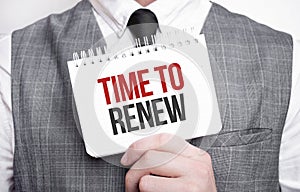 Businessman with notebook with text Time to renew