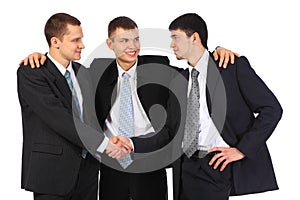 Businessman observes hand shake of two others