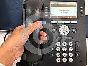 Businessman off hook IP phone calling out to customers