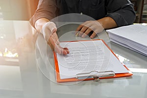 Businessman offering contract paper to his business partner for sign contract