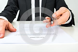 Businessman offering you to sign a document with focus to the te