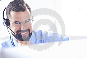 Businessman in the office on the phone with headset, Skype, FaceTime photo
