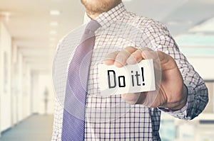 businessman in office showing card with text: Do it !