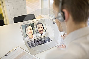 Businessman in the office on videoconference with headset, Skype photo