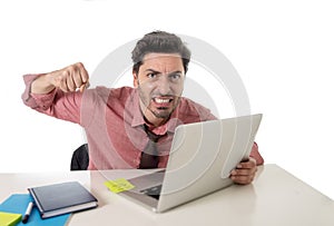 Businessman at office working stressed on computer laptop overworked throwing punch in work stress