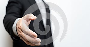 Businessman with open hands ready to seal an agreement, partners shaking hands, shaking hands, copy space. Business and office