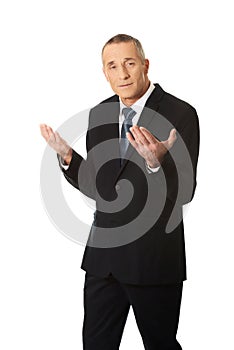 Businessman with open hands in undecided gesture