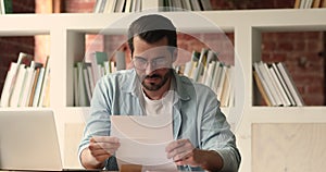 Businessman opening envelope reading letter with good news celebrating success