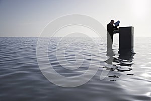 Businessman Opening Filing Cabinet In Sea