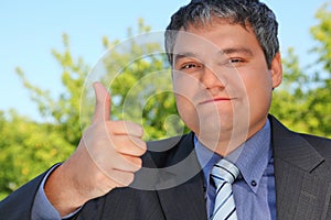 Businessman outdoor in summer with ok gesture photo