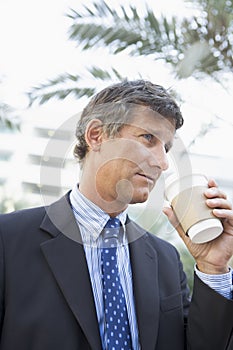 Businessman outdoors drinking coffee