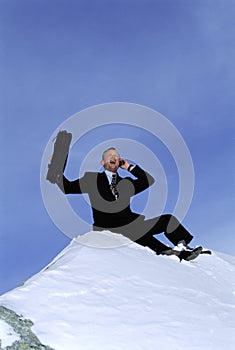 Businessman outdoors on snowy mountain using phone