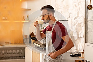 Businessman owning coffeehouse drinking cappuccino