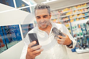 Businessman owning pet shop making selfie with rabbit