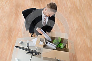 Businessman Packing Belongings In Cardboard Box