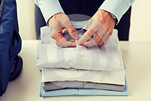 Businessman packing clothes into travel bag