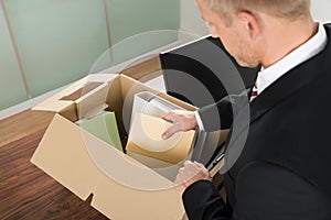 Businessman packing files in cardboard box