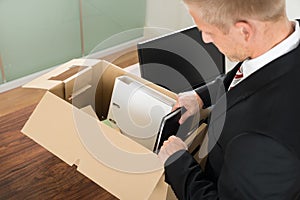 Businessman packing files in cardboard box