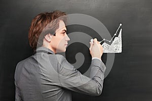 Businessman painting graph on chalkboard