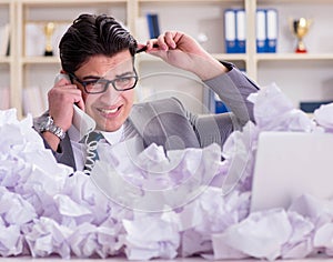 Businessman in paper recycling concept in office