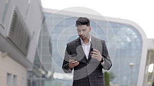 Businessman On Park Bench With Coffee Using Mobile Phone