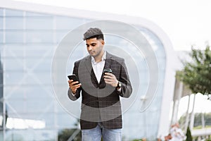 Businessman On Park Bench With Coffee Using Mobile Phone