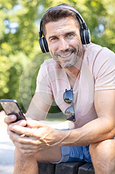 businessman on park bench with coffee using mobile phone