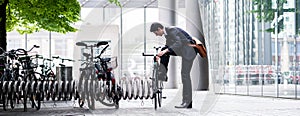 Businessman parking his bicycle in town