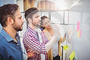 Businessman with partners looking at whiteboard in creative office