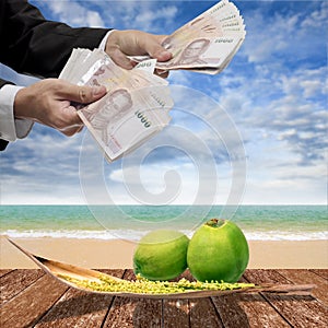 Businessman pay for coconut and spadix flower of coconut on deck