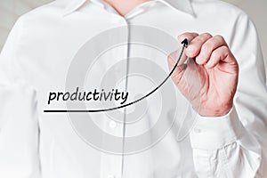 Businessman with pen draws a rising line graph with the word productivity on a virtual screen. Increasing productivity in business