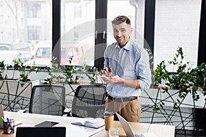 Businessman with pen and smartphone looking