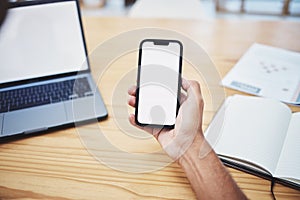 Businessman phone blank screen display on table or hand showing marketing, advertising or mockup space from above