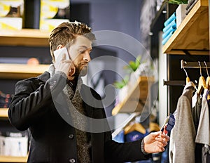 Businessman, phone call and shopping in boutique for retail, fashion and clothes in shop for sale. Male person