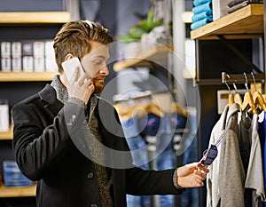 Businessman, phone call and shopping in boutique for retail, fashion and clothes in shop for sale. Male person photo