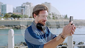 Businessman, phone and video recording for social media, post or travel location in South Africa at sea point beach. Man