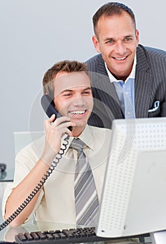 Businessman on phone and working with a colleague