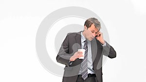 Businessman phoning while he is drinking coffee