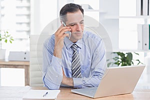 businessman phoning at his desk photo