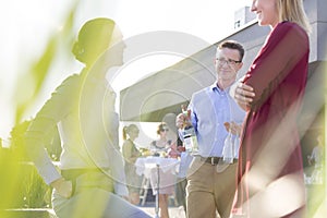 Businessman photographing colleagues during rooftop success party