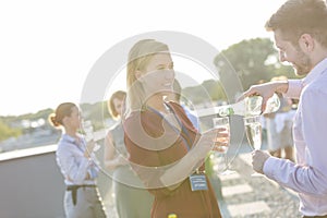 Businessman photographing colleagues during rooftop success party