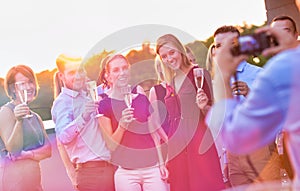 Businessman photographing colleagues during rooftop success party